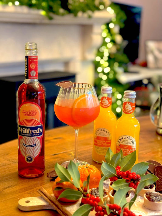 Wilfred's Chocolate Orange Spritz on a festive table with two bottles of Fentimans Mandarin & Seville Orange Jigger